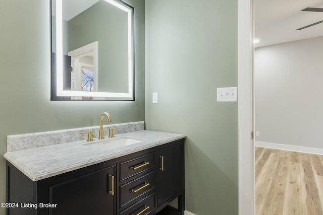 bathroom with hardwood / wood-style floors, vanity, and ceiling fan