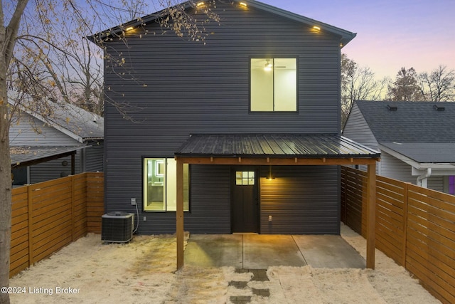 back house at dusk with central air condition unit