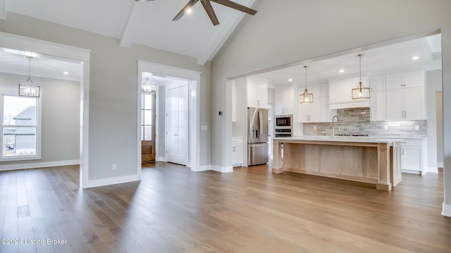 unfurnished living room featuring lofted ceiling with beams, ceiling fan, and light hardwood / wood-style floors