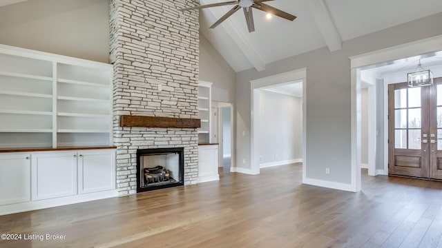 unfurnished living room with ceiling fan, french doors, light hardwood / wood-style flooring, high vaulted ceiling, and a fireplace