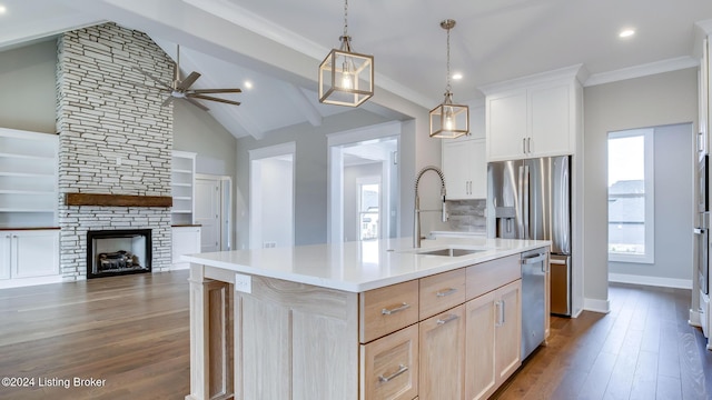 kitchen featuring sink, light brown cabinets, vaulted ceiling with beams, dark hardwood / wood-style floors, and an island with sink