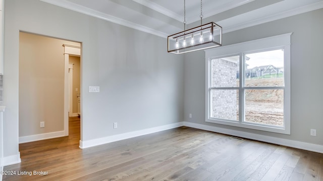 unfurnished dining area featuring wood-type flooring, an inviting chandelier, and ornamental molding