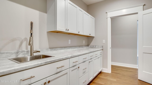 kitchen featuring light hardwood / wood-style flooring, white cabinets, and sink