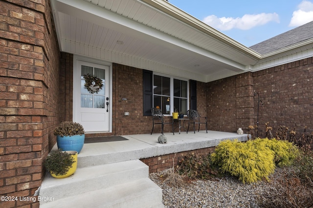 view of exterior entry featuring covered porch