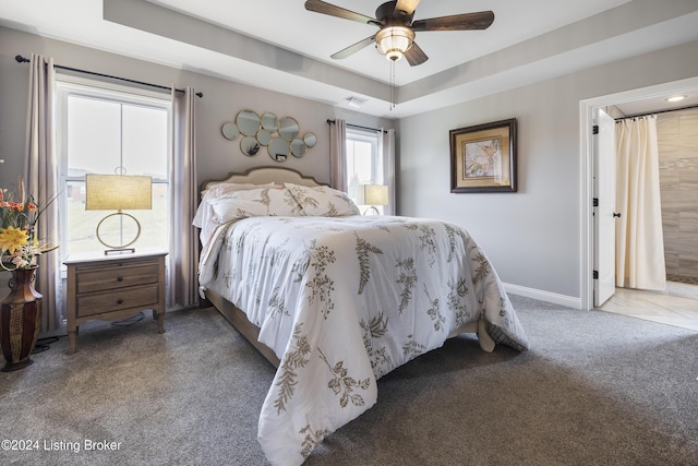 bedroom with carpet flooring, ceiling fan, and a tray ceiling