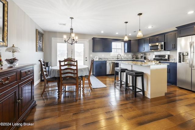 kitchen with a kitchen island, pendant lighting, dark hardwood / wood-style floors, and appliances with stainless steel finishes