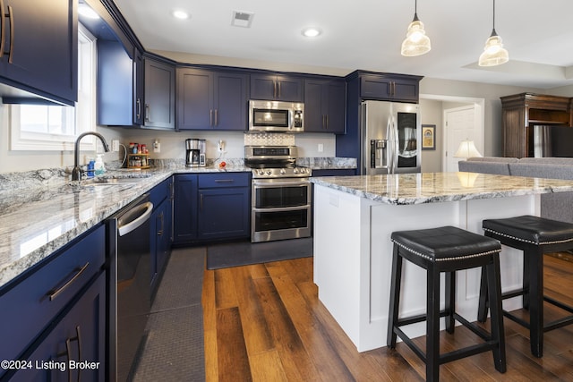 kitchen with pendant lighting, sink, a breakfast bar area, dark hardwood / wood-style floors, and stainless steel appliances