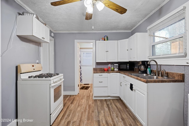 kitchen featuring sink, white cabinets, white range with gas stovetop, and light wood-type flooring