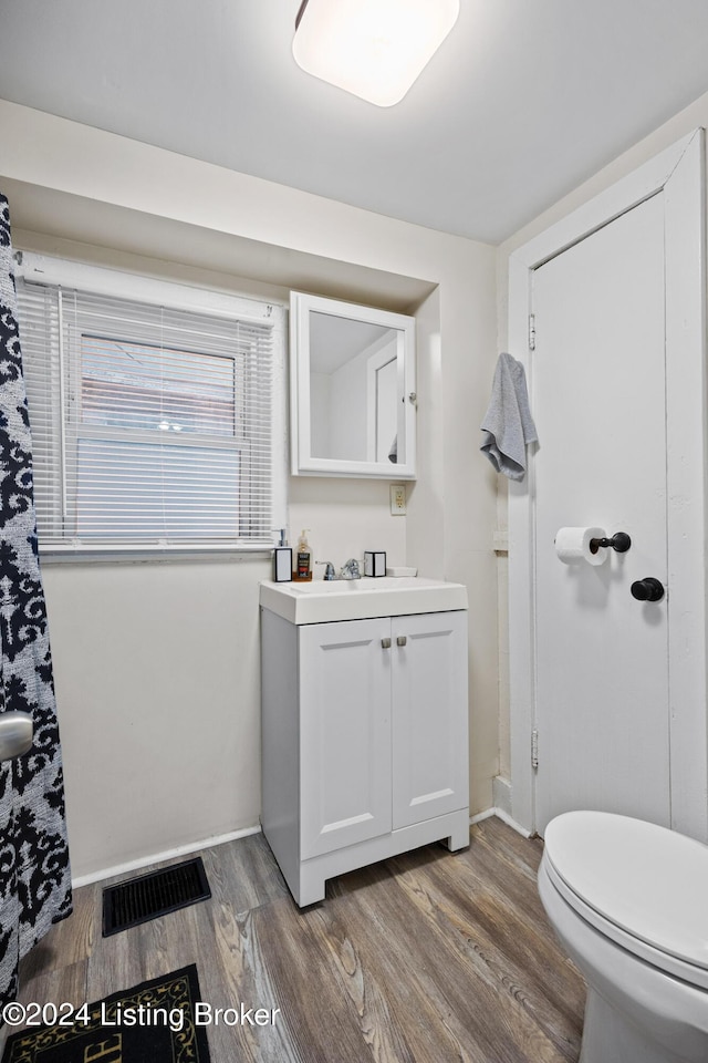 bathroom with hardwood / wood-style flooring, vanity, and toilet