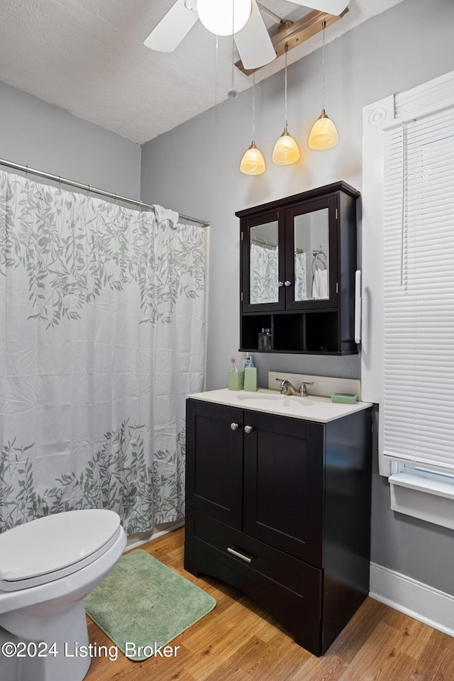 bathroom with hardwood / wood-style floors, vanity, toilet, and ceiling fan