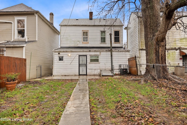 rear view of property with a lawn