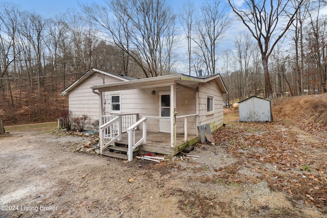 view of front of house with a deck and a storage unit