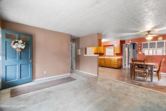 interior space featuring ceiling fan, sink, white refrigerator, a textured ceiling, and light carpet