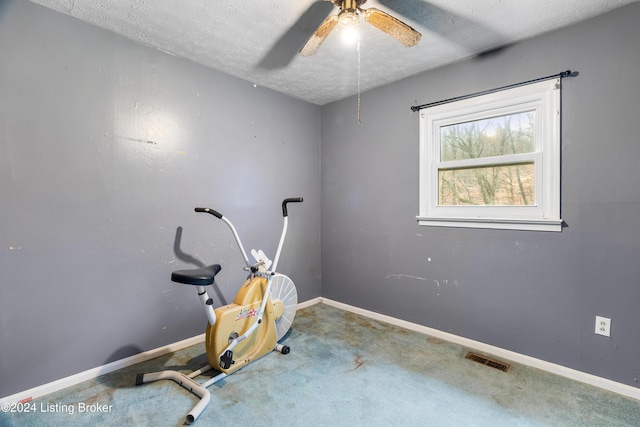 exercise area with carpet, ceiling fan, and a textured ceiling