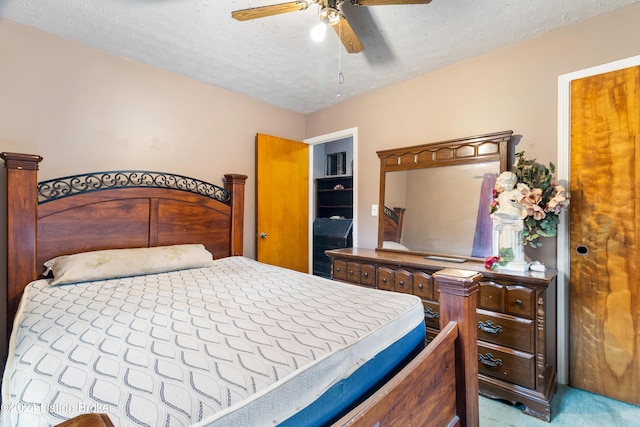 carpeted bedroom featuring a textured ceiling and ceiling fan