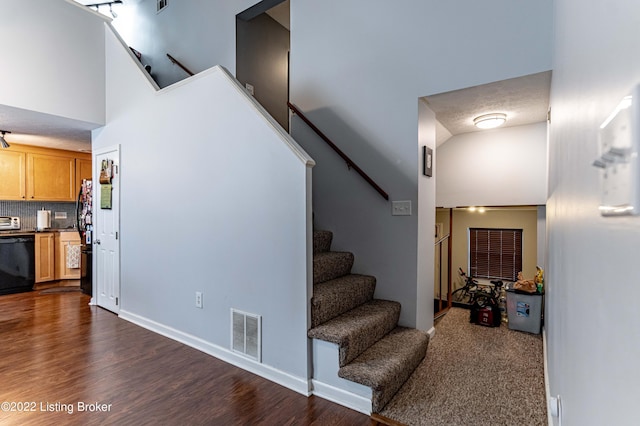 stairs with a high ceiling and hardwood / wood-style flooring