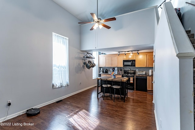 dining room with ceiling fan, dark hardwood / wood-style floors, and high vaulted ceiling