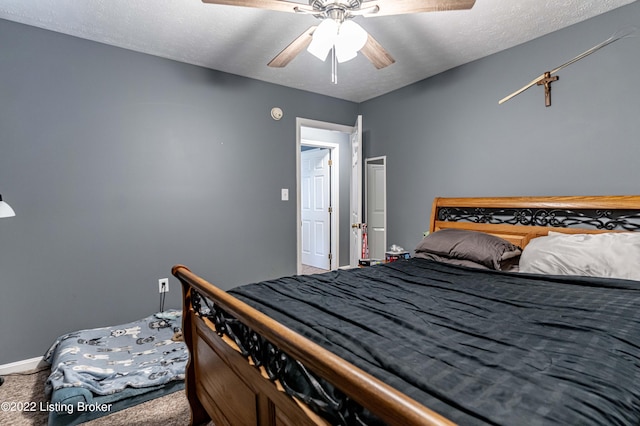 bedroom featuring ceiling fan, a textured ceiling, and carpet flooring