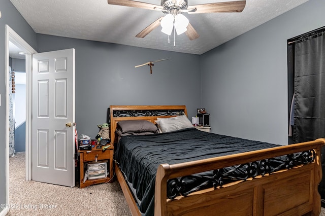 bedroom featuring ceiling fan, a textured ceiling, and carpet flooring