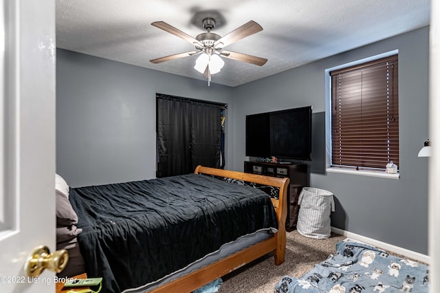 bedroom featuring a textured ceiling, ceiling fan, and carpet