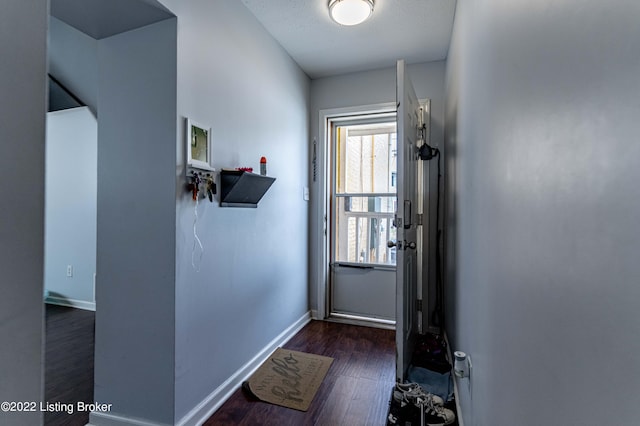 doorway with a textured ceiling and dark hardwood / wood-style floors