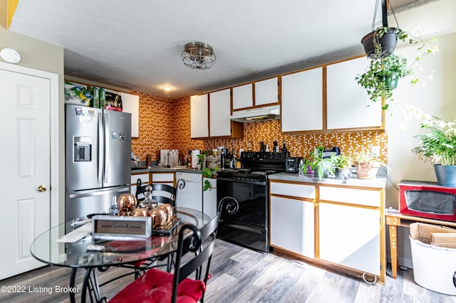 kitchen featuring decorative backsplash, white cabinetry, light hardwood / wood-style flooring, stainless steel fridge with ice dispenser, and black range with electric cooktop