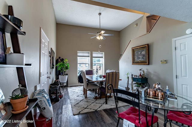 dining room with a high ceiling, ceiling fan, and hardwood / wood-style flooring