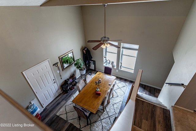 living room featuring ceiling fan, dark hardwood / wood-style flooring, and a high ceiling