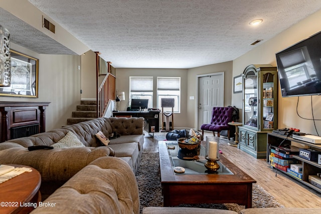 living room featuring a textured ceiling and wood-type flooring