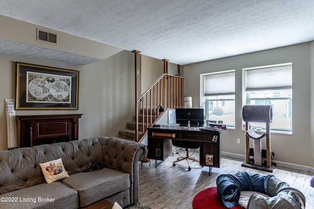 home office with a textured ceiling and light hardwood / wood-style floors