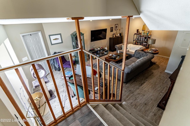 stairs with vaulted ceiling and hardwood / wood-style flooring