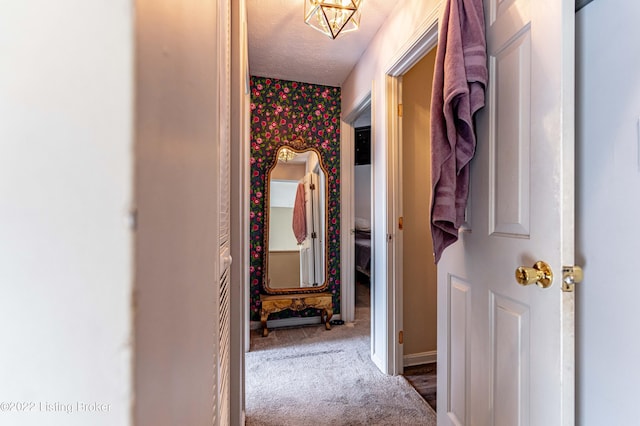 hallway with a textured ceiling and carpet