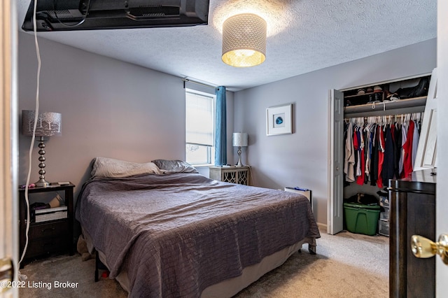 carpeted bedroom featuring a textured ceiling and a closet