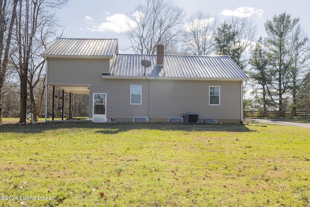 back of house featuring a lawn and central air condition unit