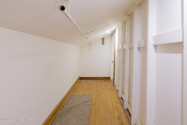 hallway with lofted ceiling and light wood-type flooring