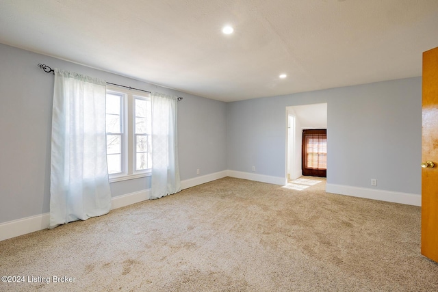 unfurnished room with light carpet