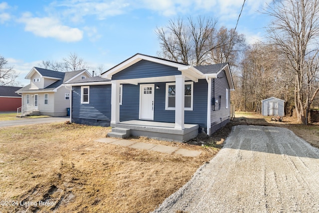 bungalow-style home with a storage unit and a porch