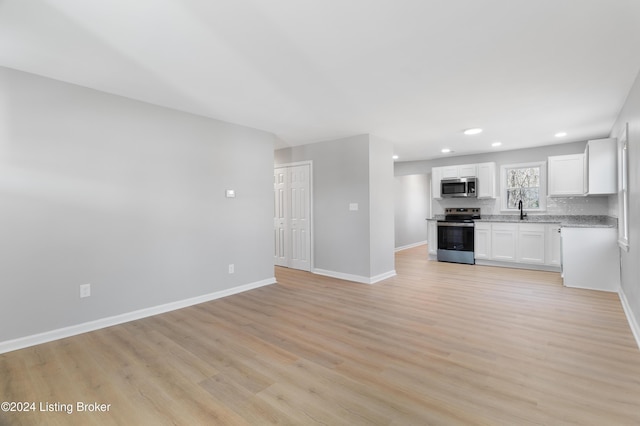 kitchen with white cabinets, light hardwood / wood-style floors, sink, and stainless steel appliances