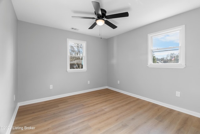 empty room featuring ceiling fan, plenty of natural light, and light hardwood / wood-style flooring