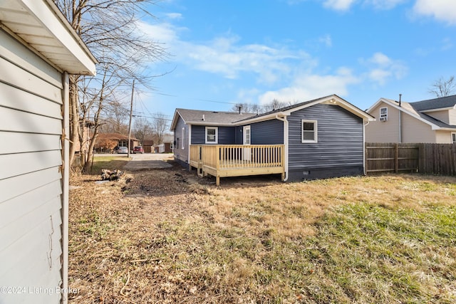 rear view of house with a yard and a wooden deck