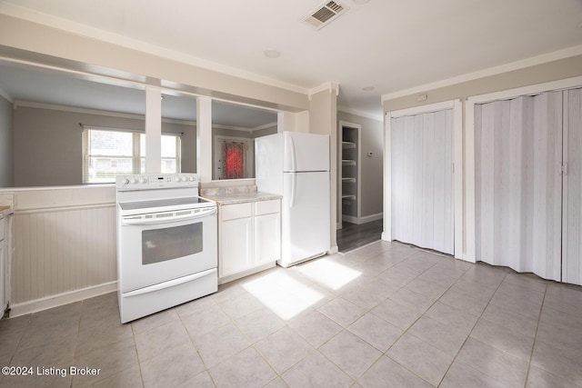 kitchen with light tile patterned floors, white appliances, and crown molding