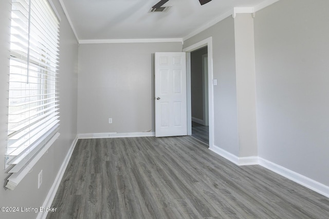 empty room with wood-type flooring and ornamental molding