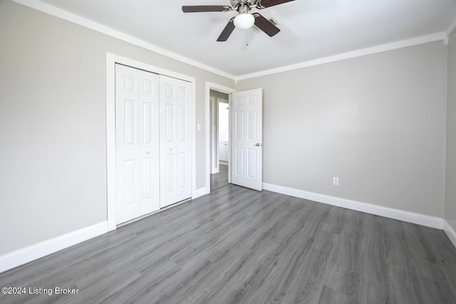 unfurnished bedroom featuring dark hardwood / wood-style floors, ceiling fan, ornamental molding, and a closet