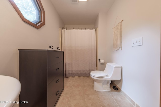 bathroom with tile patterned flooring, a shower with shower curtain, and toilet