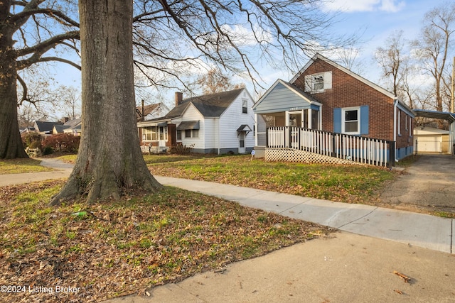 bungalow-style house featuring covered porch and an outbuilding