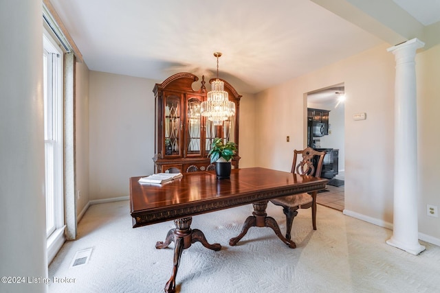 carpeted dining area with ornate columns and a notable chandelier