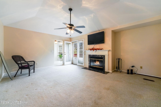 unfurnished living room with carpet floors, a premium fireplace, ceiling fan, and vaulted ceiling