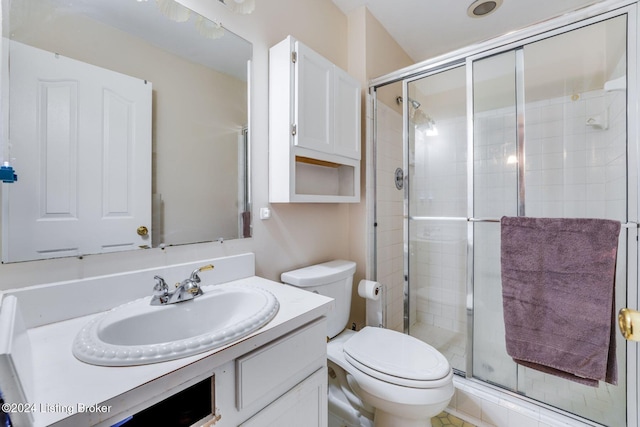 bathroom featuring vanity, an enclosed shower, and toilet