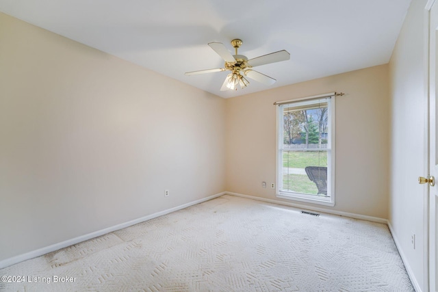 carpeted spare room featuring ceiling fan