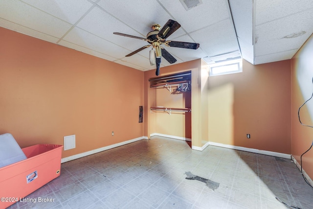 interior space with a paneled ceiling, ceiling fan, and a closet